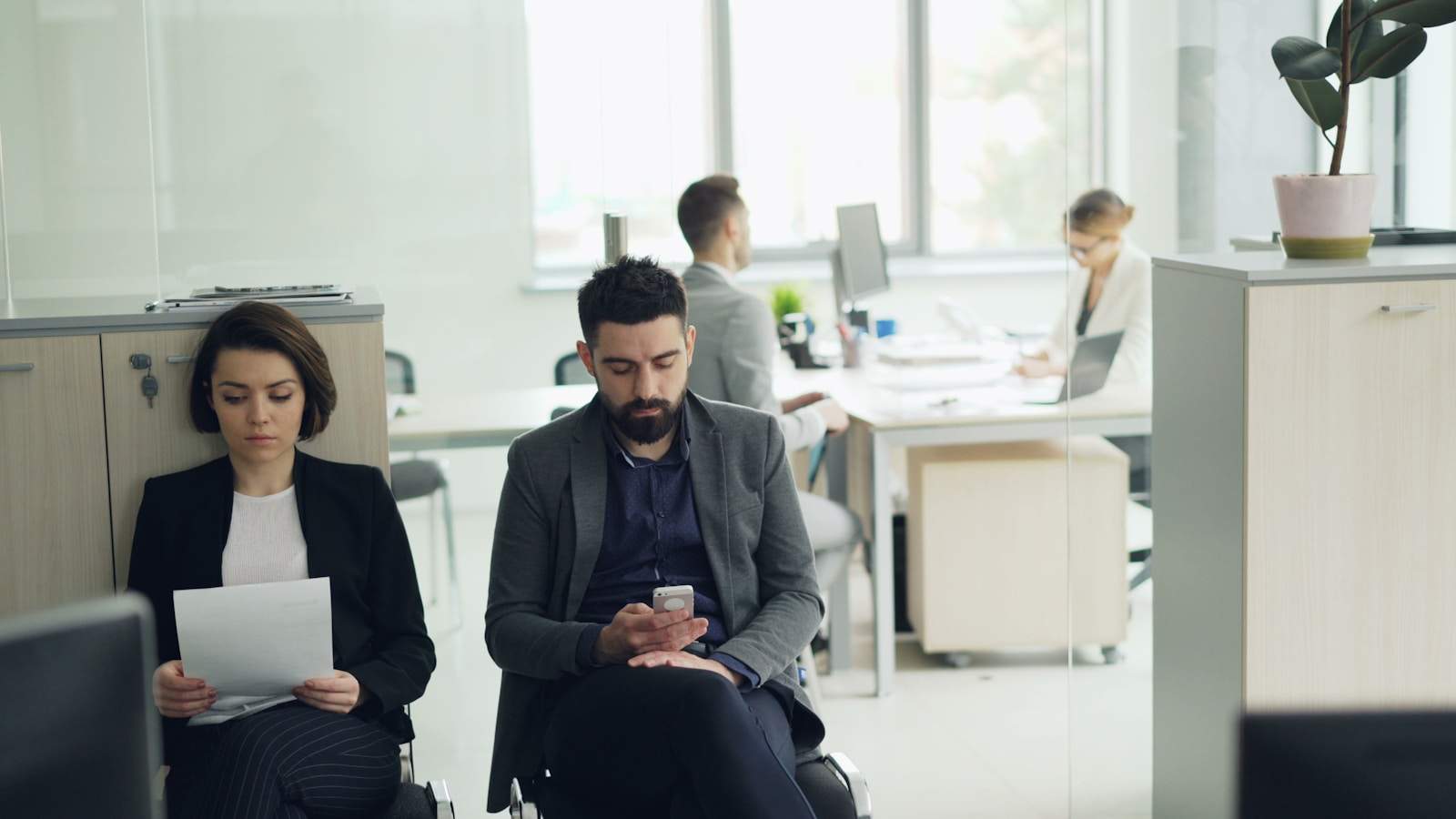 Two people waiting in an office lobby